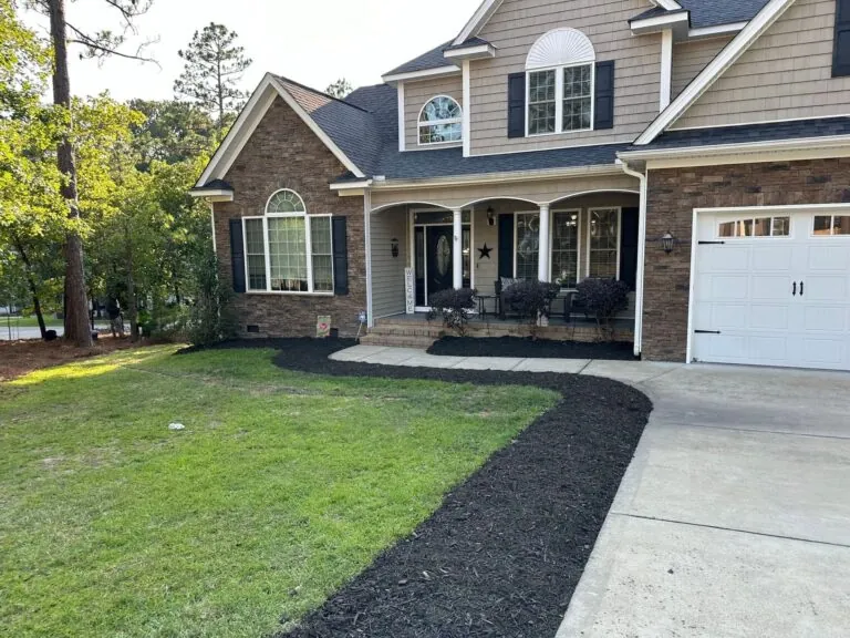 Backyard fence line with fresh mulch beds